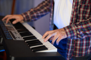 Obraz premium A close-up of hands playing a digital keyboard synthesizer