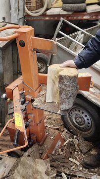 Male lumberjack using an electric hydraulic log splitter