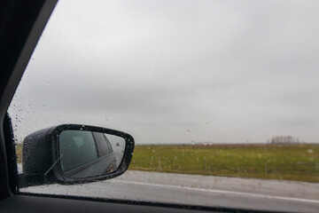 Obraz premium View in the side mirror of a car on road.