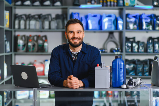 Smiling auto parts store salesman working at desk
