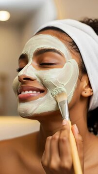 Happy African Woman Applying Green Clay Face Mask with Brush