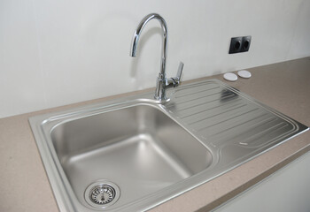 Fototapeta premium Kitchen countertop with a metallic kitchen sink and stainless steel faucet