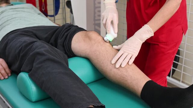 Ultrasound therapy applied to knee during physiotherapy session. Handheld transducer delivers sound waves to soft tissue, improving circulation, reducing pain, supporting muscle and joint recovery