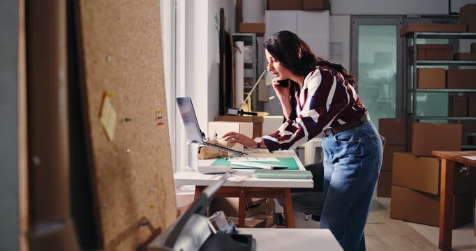 Ecommerce, phone call and laptop with woman in warehouse for shipping, distribution or inventory manager. Delivery, supply chain and quality control with person in small business for supplier contact