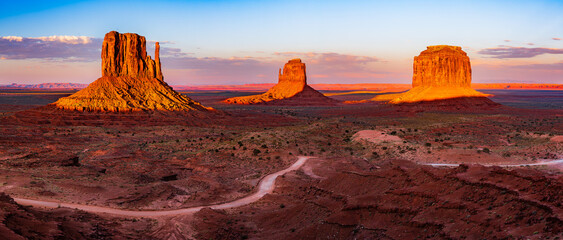 The West and East Mitten Buttes (also known as the Mittens) two buttes in the Monument Valley Navajo Tribal Park in Arizona - Utah illuminated by the sun.
