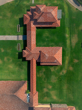 Aerial view of the striking architectural design with red tiled roofs contrasting against the lush green lawns, Lujan de Cuyo, Mendoza Province, Argentina.