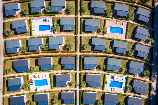 Aerial view of neat rows of villas, each a private sanctuary with pools shimmering under the sun's gaze, a mosaic of modern living, Rovinj, Istria County, Croatia.