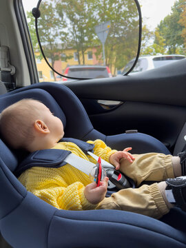 Smiling Baby in Car Seat with Yellow Sweater and Hat Road trip
