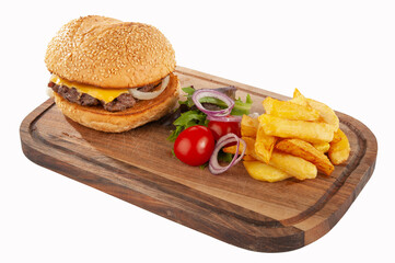 Hamburger with potatoes and vegetables on a wooden board