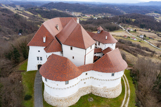 Aerial view of Veliki Tabor Castle's red roofs contrasting against white walls, nestled among green hills, Desinic, Krapinsko-zagorska zupanija, Croatia.