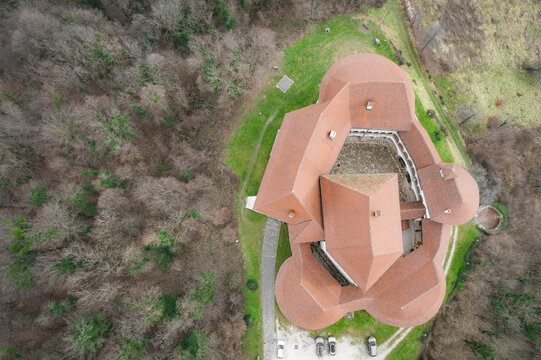 Aerial view of the iconic Veliki Tabor castle standing proudly amidst a sea of green trees, its red roofs a stark contrast to the verdant landscape, Desinic, Krapinsko-zagorska zupanija, Croatia.
