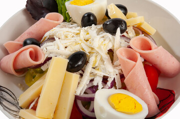 Salad with ham, tomatoes, eggs, olives, yellow cheese and onion