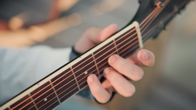 closeup hands on acoustic guitar fretboard showing unspecified person practicing fingerstyle technique, ring on finger, warm wood tones, detailed chord shapes, precise finger placement, tutorial mood