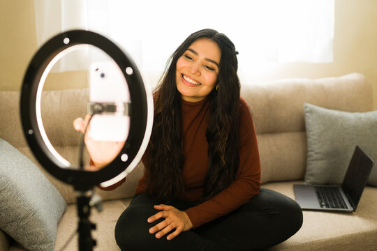 Woman vlogging with smartphone and ring light, filming content for social media, influencer lifestyle