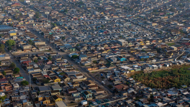 Aerial view of densely packed houses and buildings create a textured mosaic under the soft light, Kraaifontein, Cape Town, South Africa.