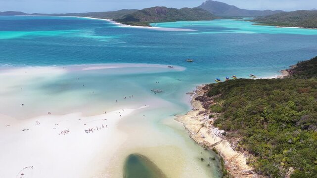 Epic aerial revealing tourists and snorkelers at Whitehaven beach in the Whitsunday Islands, Australia, a pristine landscape famous for its pure silica sand and crystal-clear turquoise waters.