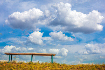 Bench against blue sky with light clouds. Bottom view