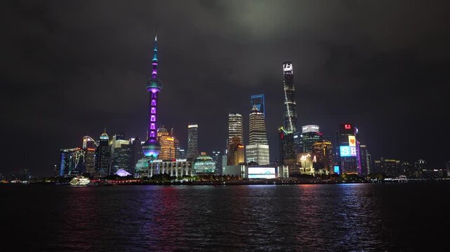 Shanghai, China: Static footage of the light of the famous Shanghai skyline facing the skyscrapers of Pudong financial district reflection in the water the Hangpu river at dusk in China.
