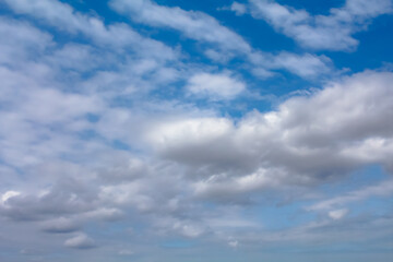 Fototapeta premium The sky is blue with a few clouds scattered throughout. The clouds are white and fluffy, giving the sky a peaceful and serene appearance.