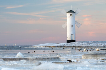 Fototapeta premium Stawa Młyny Beacon in Swinoujscie During Frozen Winter on the Baltic Sea