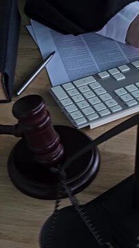 Law office setup shows tools of the trade with keyboard, gavel, and legal documents on a desk during the workday