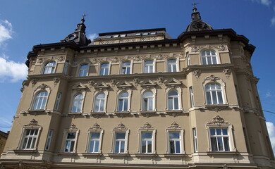 Fototapeta premium Historical Building Facade in Lviv with Grey Stone Exterior and Characteristic European Windows