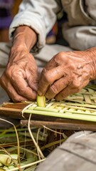 Elderly hands intricately weaving natural green palm leaves creating a textured basket pattern with soft natural lighting highlighting the detailed craft and organic materials