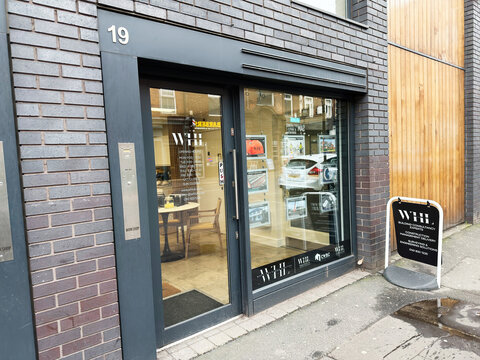 Whl Building Consultancy storefront in Manchester UK with glass door and display boards outside signage