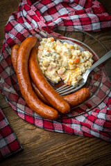 Thin sausages with vegetable salad on plate.