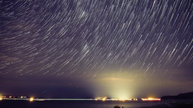 Time-lapse of stars and planets over ocean sea waters.