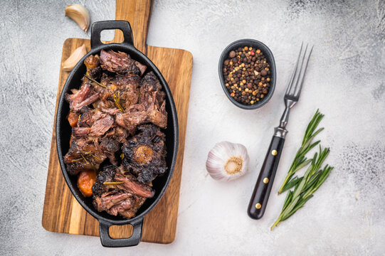 Homemade beef oxtail ragout in cast iron skillet, gelatin rich slow cooked meat with garlic and rosemary