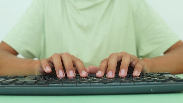 Close up of hands typing fluidly on a black keyboard over a mint green mat, clean background, soft lighting, emphasizing focus, digital fluency