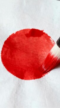 Vertical video: Blending red wash, brush coming right filling gap and evening hue on paper at table