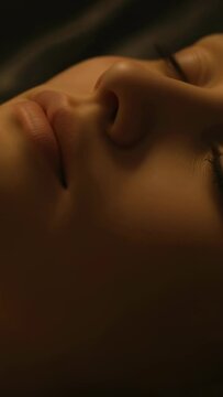 Vertical video: Breathing adult female resting eyes closed in bedroom, with pillow and sheets