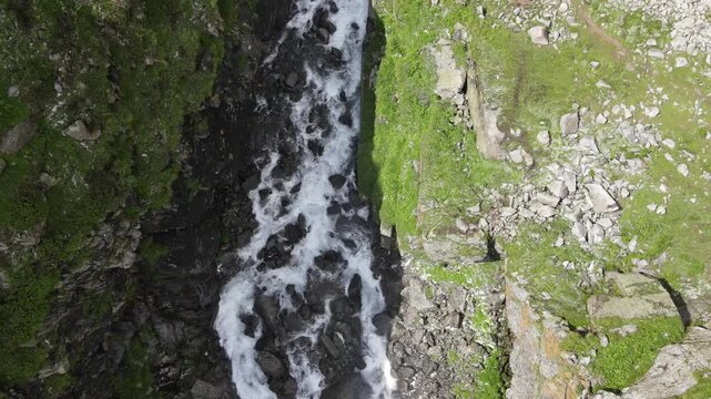 A top down aerial shot of a creek with water flowing down stream. 