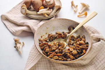 Fototapeta premium Finely chopped chanterelle, oyster and champignon mushrooms fried with carrots and onions