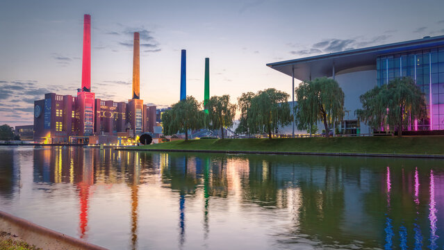 Kraftwerk und Autostadt Wolfsburg bei Abendlicht - Ansicht des beleuchteten Kraftwerks von Volkswagen und der direkt angrenzenden Autostadt Wolfsburg bei Sonnenuntergang, mit farbigen Reflektionen im 