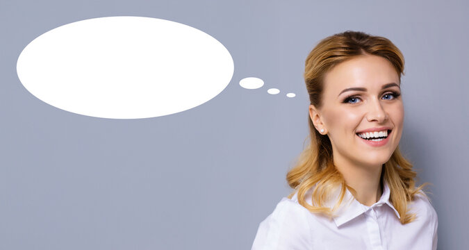 Portrait image of expressive emotional smiling young businesswoman business woman with white empty mockup speech bubble. Happy cheerful cute blond haired girl, isolated grey gray background