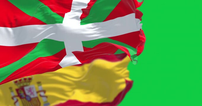 Basque Country and Spanish flags waving isolated on green background