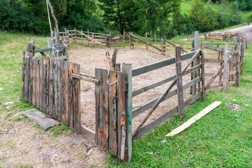 Rustic Wooden Animal Pen with Improvised Corral Fence and Gate on Green Countryside Pasture, Empty Livestock Enclosure on Rural Farm