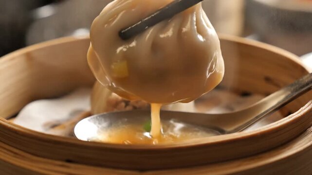 Close-up of a Savory Xiaolongbao Soup Dumpling Lifted by Chopsticks, Rich Broth Dripping, Served in a Traditional Bamboo Steamer
