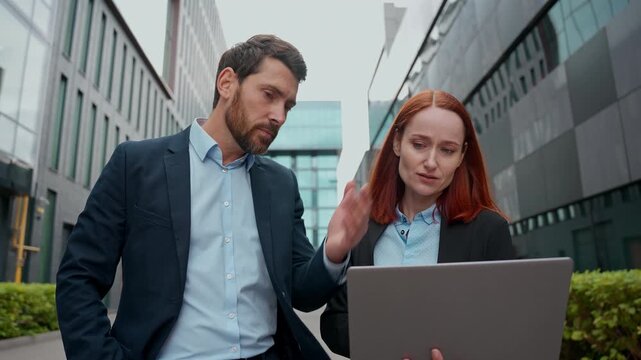 Caucasian businessman boss woman employee showing mistake bad work result laptop female worker company leader dissatisfied looking data online talking scolding computer screen wrong failure in city