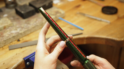 Jeweler checking ring size with measuring mandrel.