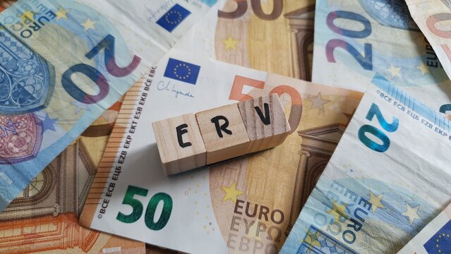 ERV acronym made of wooden letter cubes on pile of Euro banknotes. Einkommensbezogene Rentenversicherung (Income-Based Pension Insurance)