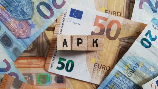APK acronym made of wooden letter cubes on pile of Euro banknotes. Altersvorsorgekonto (Retirement Savings Account)