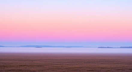 Fototapeta premium A serene landscape at dusk with a pink and purple sky over a vast field