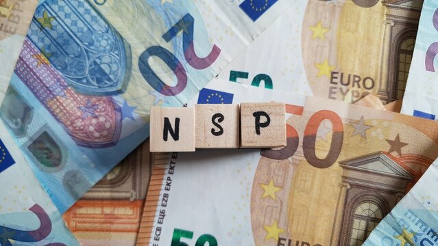 NSP acronym made of wooden letter cubes on pile of Euro banknotes. Nationale Sparkassenpolitik (National Savings Policy)