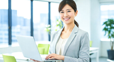 PCを持ち笑顔で働くビジネス女性