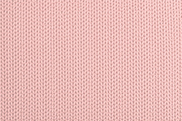 Obraz premium Close-up of pink knitted fabric with soft wool texture. Seamless textile background suitable for fashion design, winter clothing concepts, cozy materials, feminine and pastel backgrounds.