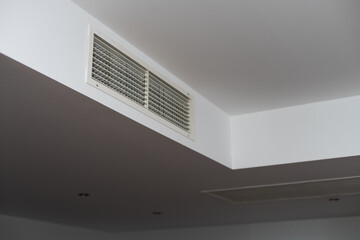 Ceiling mounted cassette type air conditioner and modern lamp light on white ceiling. duct air conditioner.